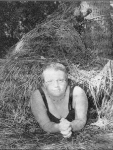 Heather Tucker of Ashland, WI peeks out of a debris hut